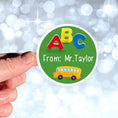 Load image into Gallery viewer, This image shows a hand holding the personalized school sticker.