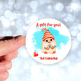 Load image into Gallery viewer, This image shows the personalized holiday sticker being held on one finger over a background of bubbles.