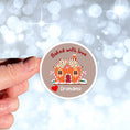Load image into Gallery viewer, This image shows the personalized holiday sticker being held on one finger over a background of bubbles.