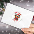 Load image into Gallery viewer, This image shows the Personalized Holiday Stickers - Highland Cow Christmas on the back of an envelope.