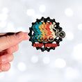 Load image into Gallery viewer, This image shows a hand holding the Keep Biking - Gear Die-Cut Sticker