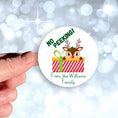 Load image into Gallery viewer, This image shows the personalized holiday sticker being held on one finger over a background of bubbles.