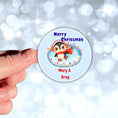 Load image into Gallery viewer, This image shows a hand holding the Personalized Holiday Stickers - Penguin Christmas.
