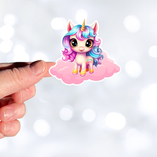 This image shows a hand holding the pink chibi unicorn sticker.