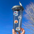 Load image into Gallery viewer, This image shows a water bottle with some of the Let's Sail Away stickers applied.
