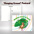 Load image into Gallery viewer, This image shows the Hanging Around at Home! postcard with a sloth on a swing with a large leaf behind.