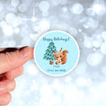 Load image into Gallery viewer, This image shows the personalized holiday sticker being held on one finger over a background of bubbles.