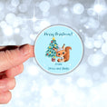 Load image into Gallery viewer, This image shows a hand holding the Personalized Holiday Stickers - Squirrel Christmas.