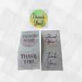 Load image into Gallery viewer, This image shows four fonts printed on the gray patterned paper labels, and one holographic gold Thank You! label.