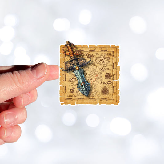 This image show a hand holding the Pirate Dagger on a Map Die-Cut Sticker.