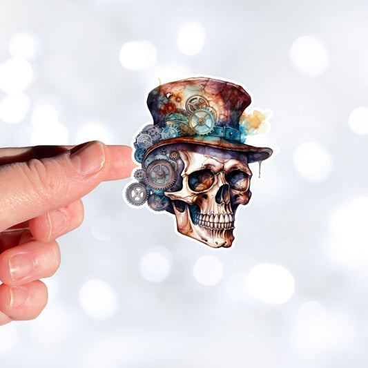 This image shows a hand holding the Steampunk Skull 3 Die-Cut Sticker.