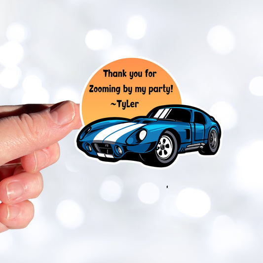 This image shows a hand holding the Zooming by sticker.