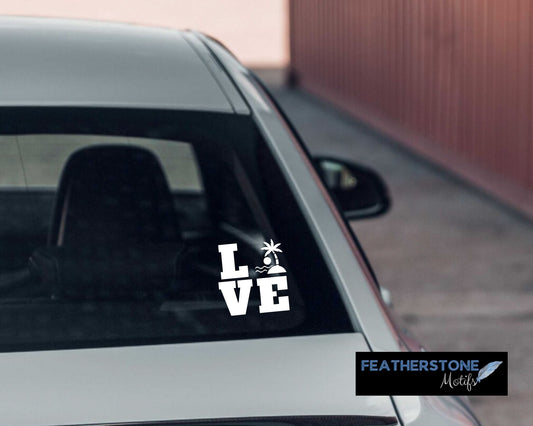 Love the beach? Then show it with this beach themed love square vinyl decal! Available in 4 sizes and 10 colors, these vinyl decals make great gifts for everyone. This image shows the Beach Love Square vinyl decal on the back window of a car.