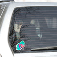 Load image into Gallery viewer, This individual die-cut sticker is one you either like or don't like; it's very unique! Featuring a 3D paint drip in pinks and purples over a green and blue paint swath, this sticker is hard to explain but pretty interesting to see. This image shows the 3D Drip sticker on the back window of a car.