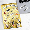 Load image into Gallery viewer, This sticker sheet celebrates all things music! Strings, brass, woodwinds, and percussion stickers that are perfect for any music lover. This image shows the sticker sheet next to an open laptop with a sticker of a music notes surrounded by leaves and vines and a sticker of a flute applied below the keyboard.