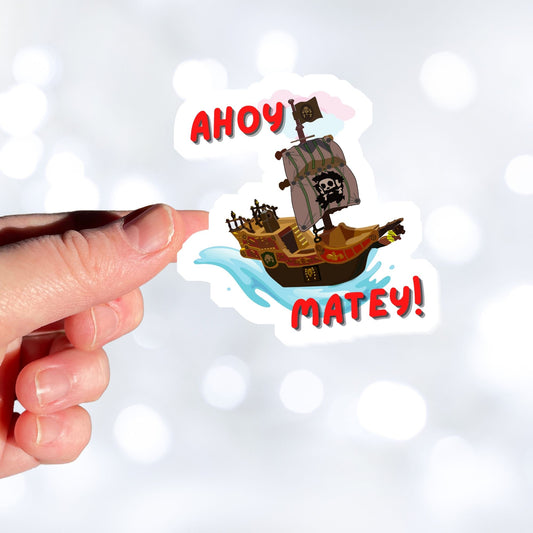 Hoist the main and prepare to board! This individual die-cut sticker is of a pirate ship under sail with the words "Ahoy Matey!" This image shows a hand holding the pirate ship sticker.
