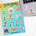 Load image into Gallery viewer, Who doesn't love going to the carnival? This sheet has stickers showing the big top, clowns, animals, and of course your favorite foods like hotdogs and cotton candy. This is an image of a laptop with stickers on it.