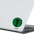 Load image into Gallery viewer, Show your love of golf with this individual die-cut sticker! This sticker shows the silhouette of a golfer about to swing, on a green golf ball background, with the word "Fore!" below. This image is of the golf sticker on the back of an open laptop.
