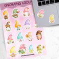 Load image into Gallery viewer, Gnomes, gnomes, and more gnomes! This sticker sheet has 16 unique gnome stickers for people who love their Gnomies. This image has the sticker sheet next to an open laptop with two gnome lady stickers applied below the keyboard.