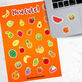 Load image into Gallery viewer, Filled with sticker images of cute fruit, this sticker sheet is sure to put a smile on anyone's face! This image shows the sticker sheet next to an open laptop with stickers of a watermelon slice, a kiwi, and an orange applied below the keyboard.