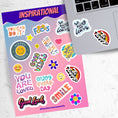 Load image into Gallery viewer, Feel good with these inspirational thoughts as stickers! This sheet has a dozen stickers with inspirational sayings, plus some smaller stickers to help brighten anyone's day. This image shows the sticker sheet next to an open laptop with a "Live and Learn" sticker and a "Be Happy" sticker applied below the keyboard.