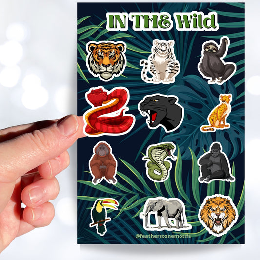 This sticker sheet has sticker images of your favorite jungle and rain forest creatures! There are a dozen different sticker images including tigers, a lion, a gorilla, snakes, and even a sloth. This image shows a hand holding a sticker of a snake over the sticker sheet.