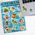 Load image into Gallery viewer, You'll walk the plank to get our A Pirates Life sticker sheet with individual stickers of treasure chests, treasure maps, pirate ships, pirates, and pirate creatures. This is an image of a laptop with stickers on it.