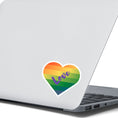 Load image into Gallery viewer, This individual die-cut sticker features a heart shape with graduated colors from orange at the top to blue at the bottom, and the word love written across. Perfect for the people you love! This image shows the Love Heart sticker on the back of an open laptop.