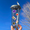 Load image into Gallery viewer, Reading, writing, and arithmetic; this sticker sheet is perfect for students, or educators, of all ages! It's filled with stickers showing all aspects of school - books, globe, crayons, backpacks, and of course a mortarboard / graduation cap! This image is of a water bottle with 5 stickers applied to it: "Well Done", an apple, crayons, pencils, and an easel with a painting.