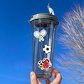 Load image into Gallery viewer, What are your favorite sports? Football, gymnastics, soccer, volleyball, cheer, baseball, hockey, tennis, or lacrosse? If you love any of these then this sticker sheet is perfect for you! This image show a water bottle with stickers of tennis rackets, a soccer ball, and a group of sports balls applied to it.