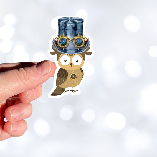 Mrs. Owl is sporting a steampunk hat with goggles and she has her own steampunk watch necklace. This image shows the Mrs. Owl sticker being held above a white background.