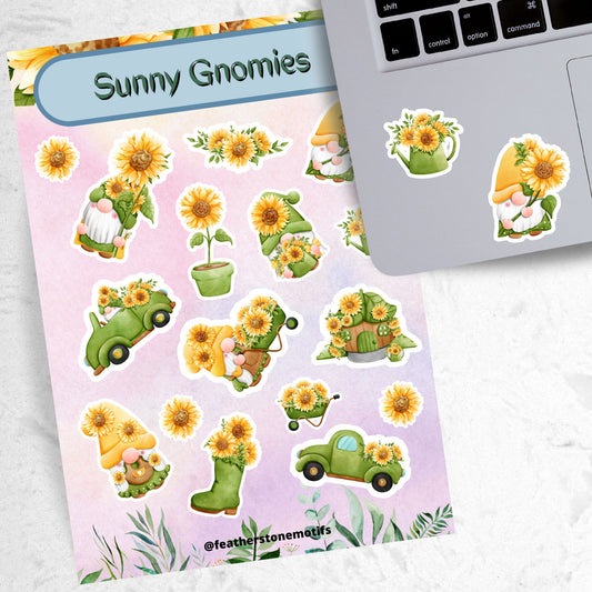 Sunflowers and Gnomes; what a perfect combination! This sticker is filled with stickers of sunflowers and gnomes with sunflowers. This image shows the sticker sheet next to an open laptop with a watering can filled with sunflowers sticker and a gnome holding a large sunflower sticker applied below the keyboard.