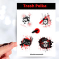Load image into Gallery viewer, Trash Polka uses red, black, and white with a combination of abstract, surrealistic, and realistic images. This sticker sheet has four larger stickers from our die-cut sticker collection combined with a smaller sticker of a raven flying across a red sun. The stickers are the Trash Polka Woman's face, Trash Polka Clock, Trash Polka Owl, and Trash Polka Sugar Skull Woman. This image shows a hand holding the Trash Polka Owl sticker above the sticker sheet.,