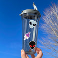 Load image into Gallery viewer, This sticker sheet is filled with aliens and UFOs with individual stickers of aliens, space ships, and alien creatures. This image is of a water bottle with some of the individual stickers on it.