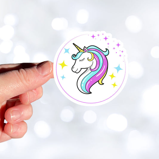 This individual die-cut sticker features a teal and purple unicorn with stars in the background. This image shows a hand holding the Unicorn sticker