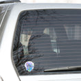 Load image into Gallery viewer, This individual die-cut sticker has a serene looking green sea turtle on a blue and purple background with splash of green. Just looking at this image is relaxing! This image shows the Watercolor Sea Turtle on the back window of a car.