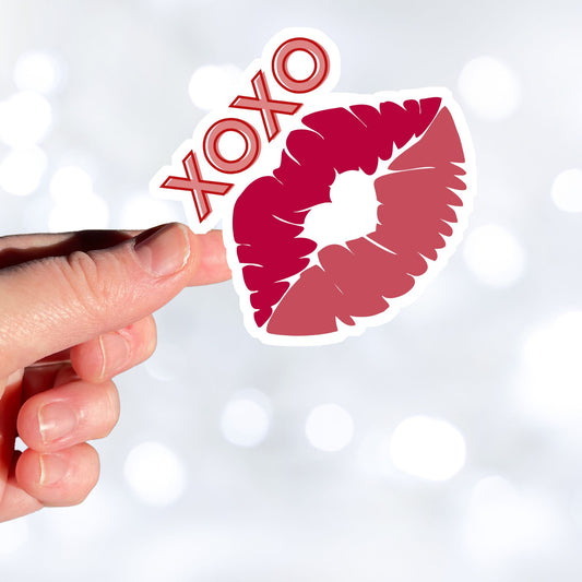 This individual die-cut sticker pretty much speaks for itself! It features a pair of lips with XOXO written above. Nuff said! This image shows a hand holding the XOXO sticker.