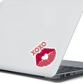 Load image into Gallery viewer, This individual die-cut sticker pretty much speaks for itself! It features a pair of lips with XOXO written above. Nuff said! This image shows the XOXO die-cut sticker on the back of an open laptop.