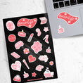 Load image into Gallery viewer, Let's celebrate mom! Mom's can do it all, and this pink aesthetic sticker sheet has sticker images of things that moms, and non-moms, enjoy like - candles, bubble baths, makeup, or coffee. This image shows the sticker sheet next to an open laptop with a sticker of a coffee cup and a sticker saying #momlife with flowers applied below the keyboard.