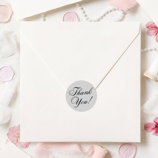 This image shows a silver Thank You! label on the back of an envelope.