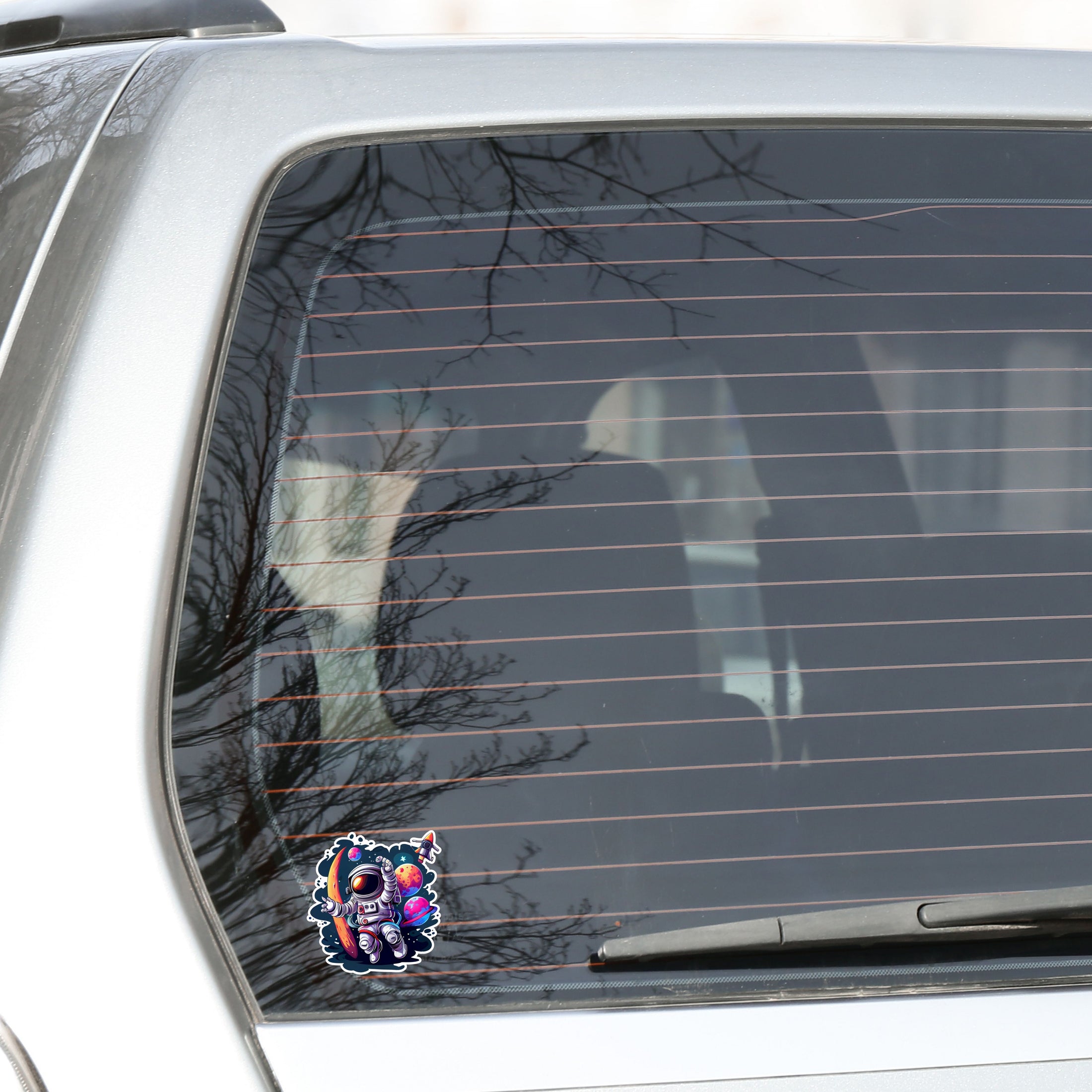 This image shows the astronaut spacewalk sticker on the back window of a car.