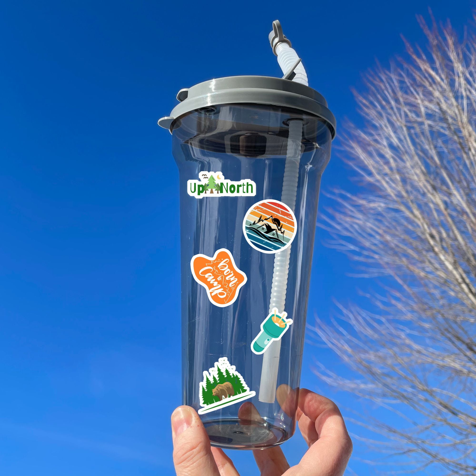 This image shows a water bottle with some of the Happy Camper stickers applied.