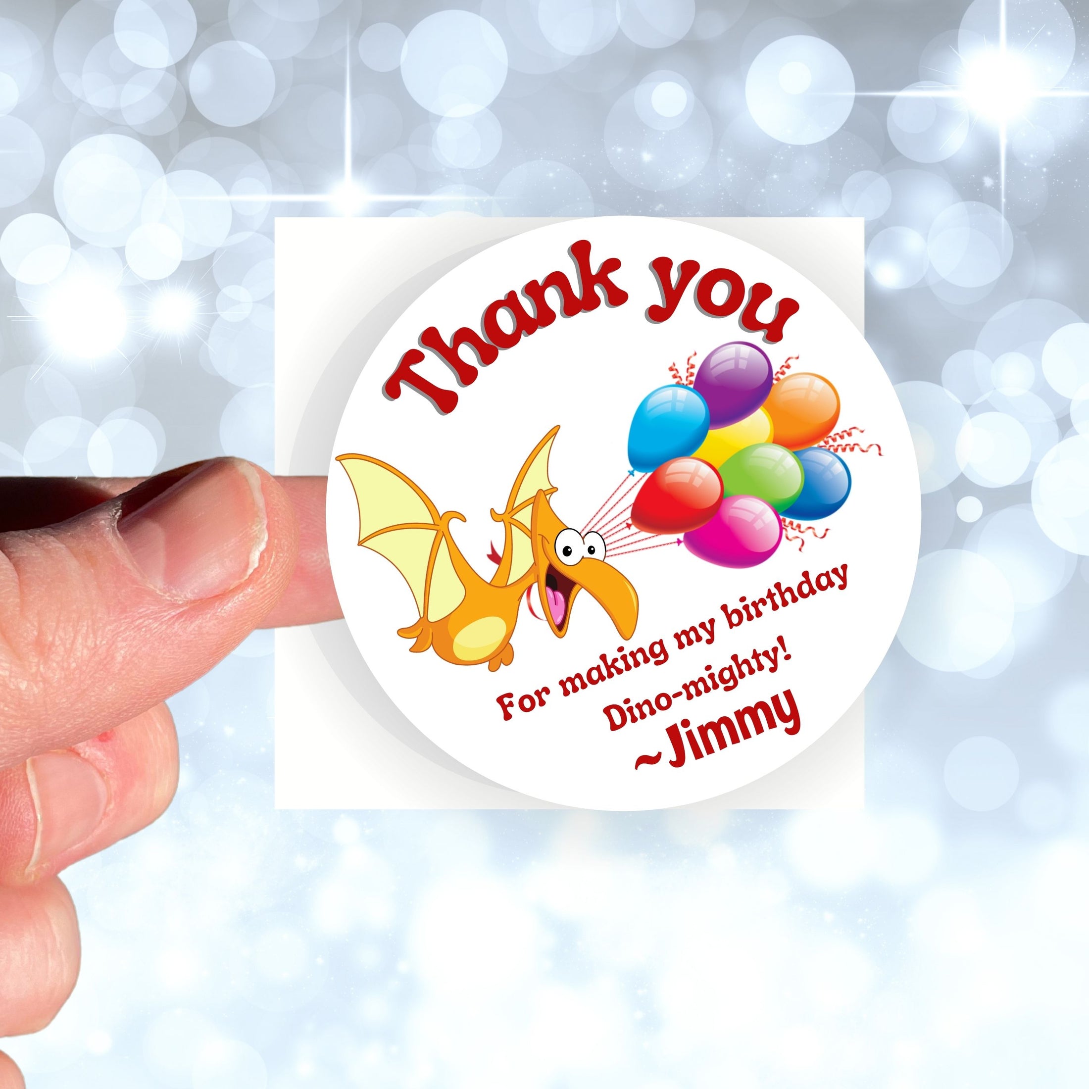 This image shows a hand holding the personalized dinosaur themed thank you sticker.