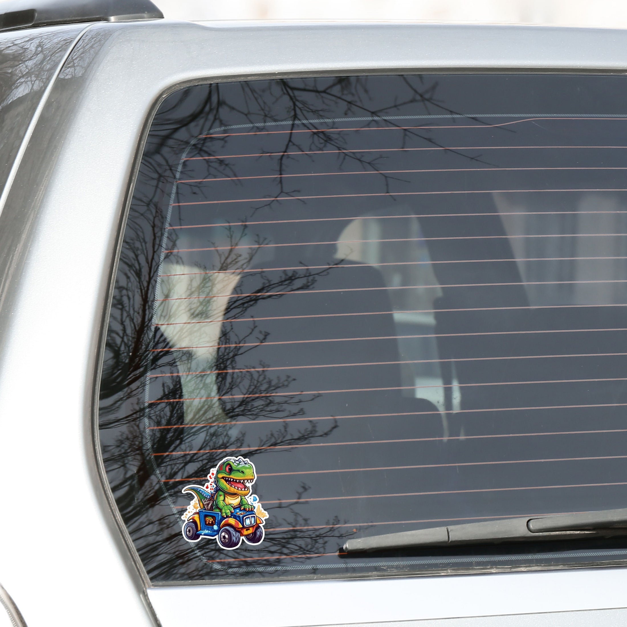 This image shows the dino on ATV sticker on the back window of a car.