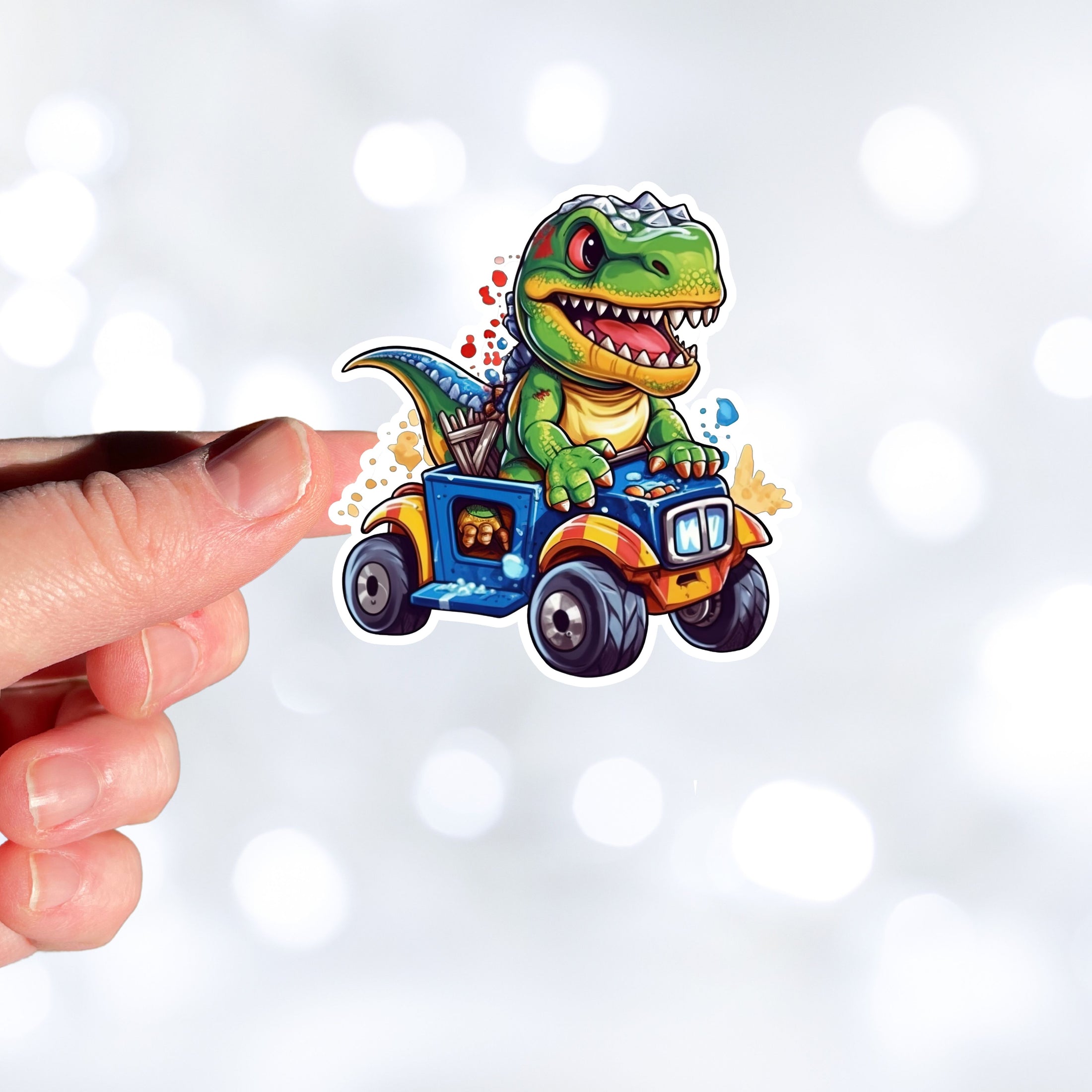 This image shows a hand holding the dino on ATV sticker.