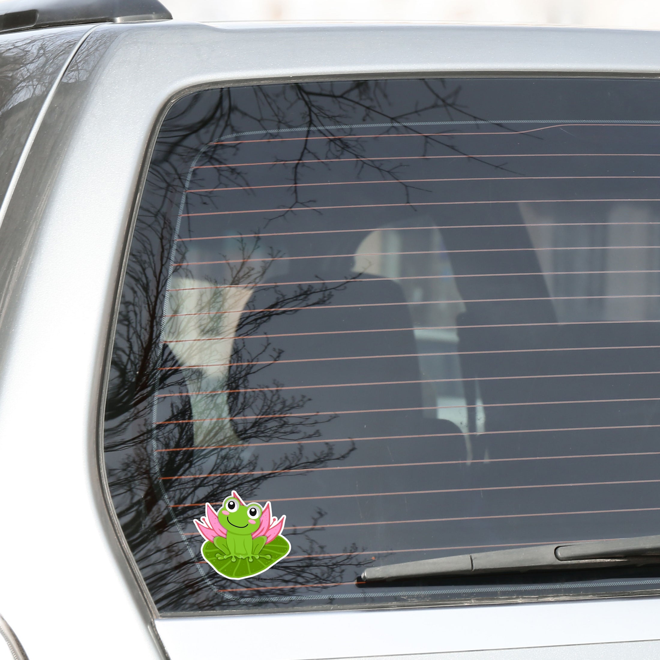 This image shows the froggy on a lily pad sticker on the back window of a car.