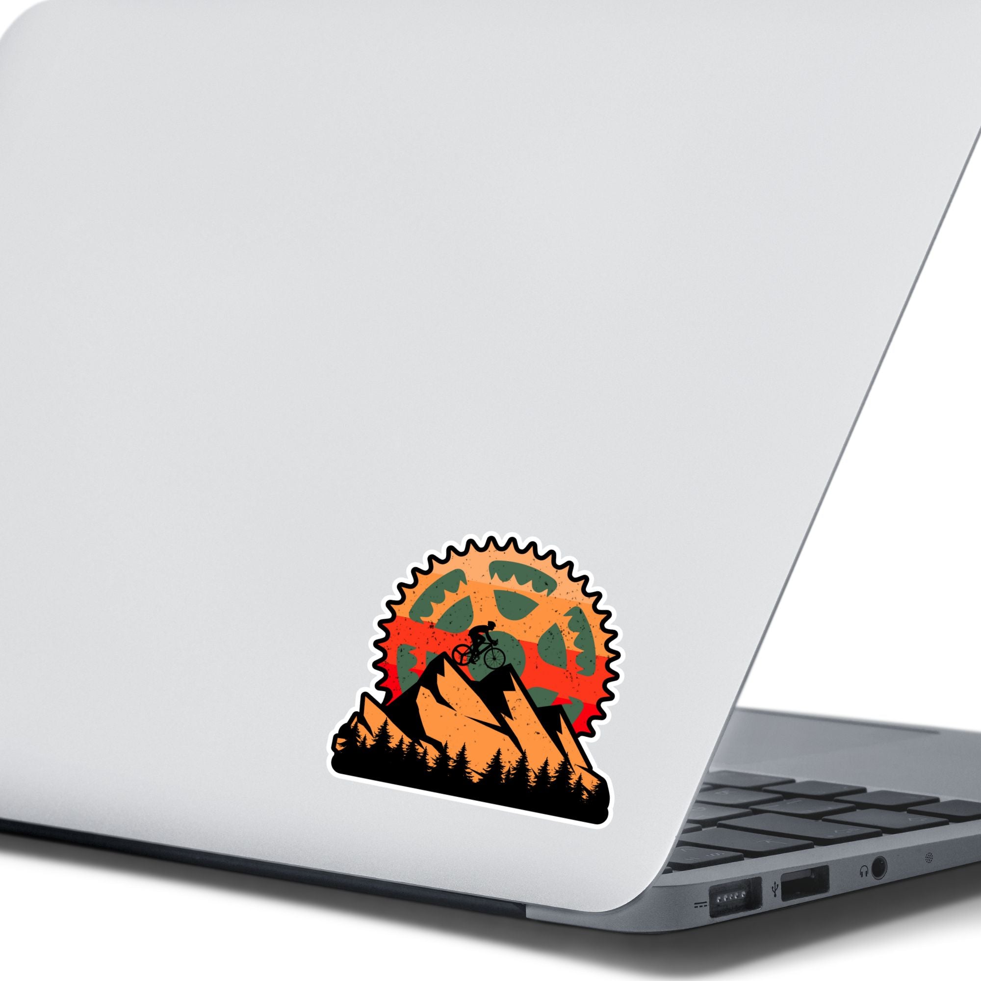 This image shows the Keep Biking - Mountain Die-Cut Sticker on the back of an open laptop.