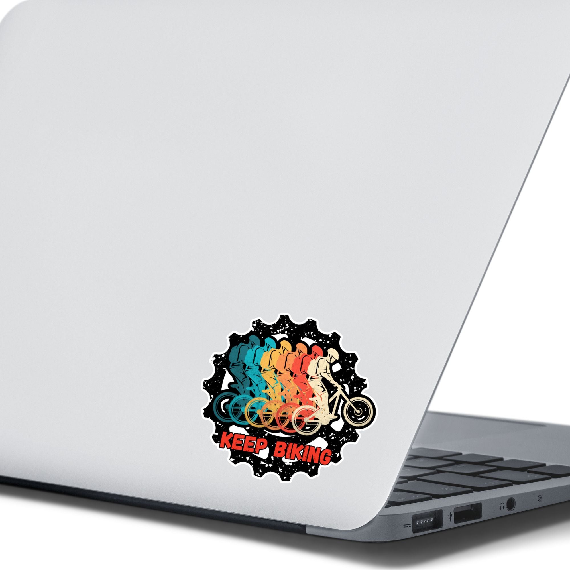 This image shows the Keep Biking - Gear Die-Cut Sticker on the back of an open laptop.