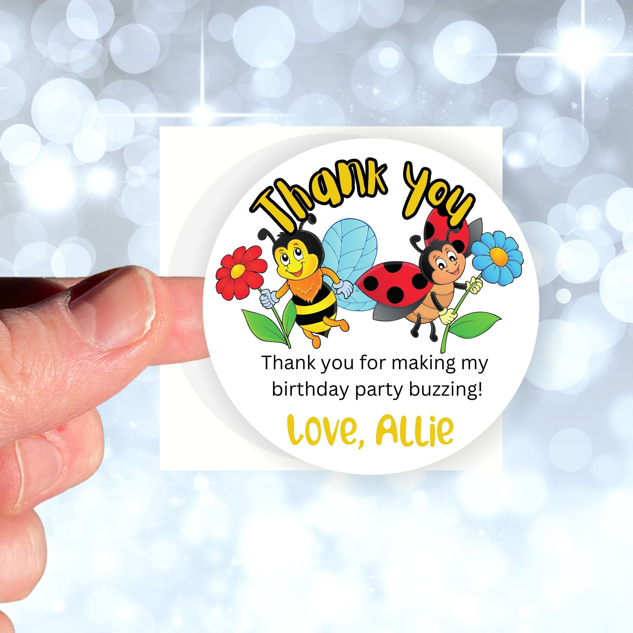 This image shows a hand holding the personalized ladybugs and bees themed thank you sticker.