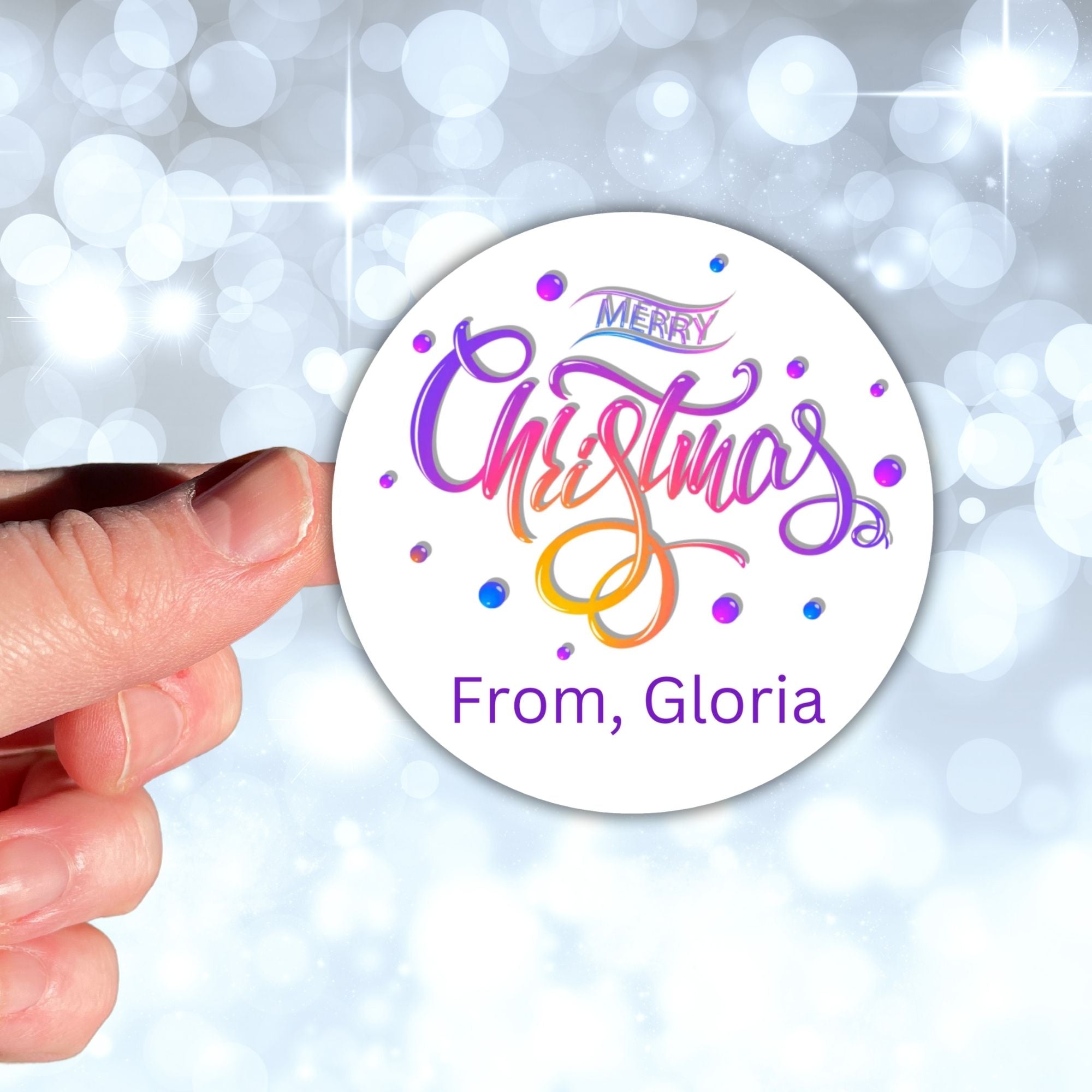 This image shows a hand holding the Personalized Holiday Stickers - Merry Christmas Purple.